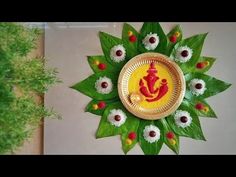 a decorative wall hanging made out of green leaves and red gandapaa on it