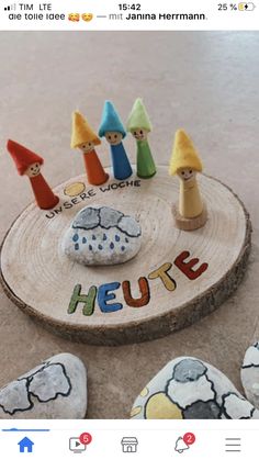 a group of little gnomes sitting on top of a piece of wood with the word heure painted on it