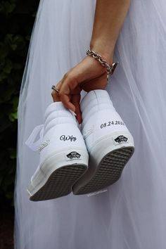 the bride is holding her wedding shoes