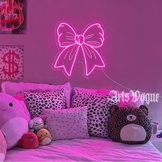 a bedroom with pink walls and stuffed animals on the bed in front of the wall