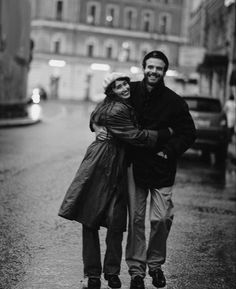 black and white photograph of two people walking down the street