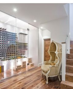 a chair sitting in front of a wine rack filled with bottles on top of a wooden floor