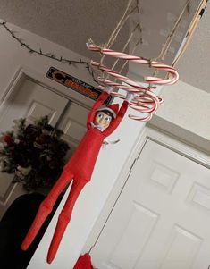 the elf is hanging from the ceiling with candy canes