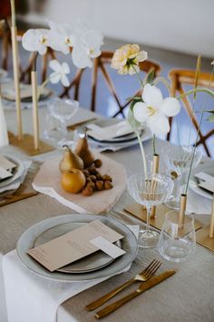 the table is set with plates, silverware and flowers