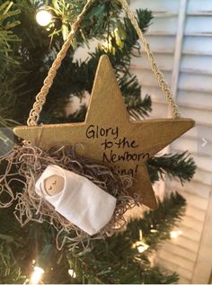 a wooden star ornament hanging from a christmas tree with the words glory to the newborn king written on it