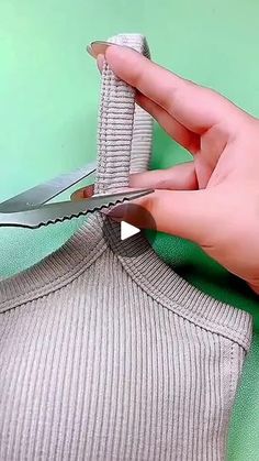 someone is cutting fabric with scissors on top of the shirt to make it look like they have been cut