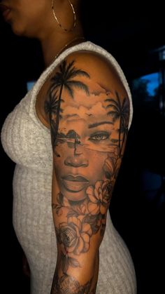 a woman's arm with tattoos on it and palm trees in the sky behind her