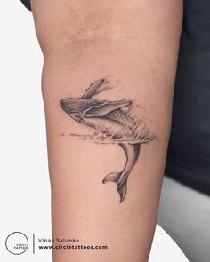 a woman's arm with a whale tattoo on it