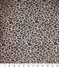 an animal print fabric with brown and black spots on it's surface, in front of a ruler