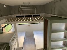 the interior of a small camper with bunk beds and kitchenette in place for cooking