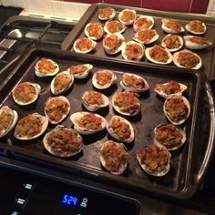 an oven with trays of open oysters on the top and bottom, ready to be cooked