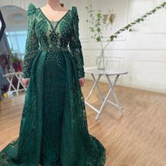 a woman in a green dress standing on a wooden floor