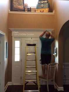 a man standing on a step ladder in front of a doorway and looking up at the sky