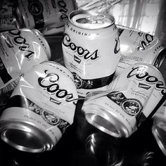 black and white photograph of soda cans stacked on top of each other