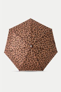 an animal print umbrella is open on a white background and it's brown with black spots