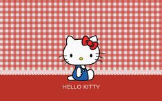 hello kitty sitting on the ground in front of a red and white checkered background