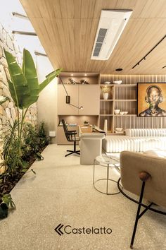 a living room filled with furniture next to a wall covered in bookshelves and plants