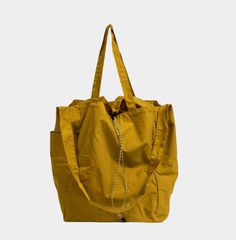 A versatile, water-repellent, 3-way packable tote bag with multiple pockets, perfect for daily use or travel. Repellent, Water Repellent, Mustard, Tote Bag, Water, Travel