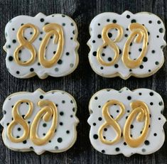 three decorated cookies with the number 80 on them, and polka dot designs in gold