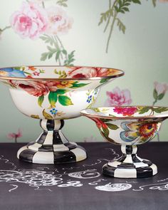 three bowls are sitting on a table with floral wallpaper in the backround