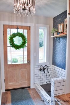 a door with a wreath on it and a bathtub in front of the door