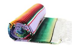 a multicolored blanket laying on top of each other next to a white background