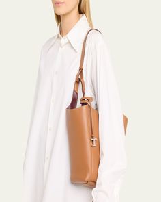 Tod's bucket bag in grained calf leather     Fixed top handles, 12.6" drop     Hook closure     Removable pendant with branded metal T Timeless accessory    Interior, two slip pockets     Lining: Leather/nylon/polyurethane    Approx. 12.6"W x H 11.8"H x 4.7"D    Made in Italy Elegant Tan Bucket Bag With Leather Handles, Tan Bucket Bag With Detachable Handle, Tan Tote Bucket Bag With Detachable Handle, Tan Top Handle Bucket Bag With Gold-tone Hardware, Classic Calf Leather Bucket Bag For Office, Classic Calf Leather Bucket Bag For Business, Timeless Bucket Bag With Detachable Strap For Work, Elegant Tan Leather Bucket Bag, Modern Calf Leather Bucket Bag For Business