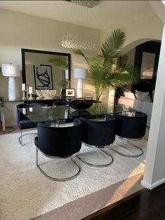 a dining room table with four chairs and a plant in the middle of the room