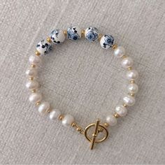 This Beautiful Freshwater Pearl Bracelet Features A Gold Toggle Clasp And 4 Blue Floral Center Beads. Handmade. 7” Length. Blue And White Bracelet, Toggle Clasp Bracelet, Bride Headband, White Bracelet, White Bracelets, Freshwater Pearl Bracelet, Beads Handmade, Bracelet Vintage, Stretchy Bracelets