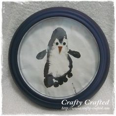 an image of a penguin in a glass frame on the wall above a toilet paper roll