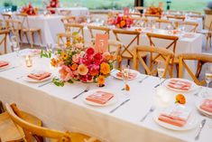 the table is set with pink and orange flowers