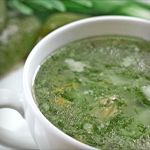 a white bowl filled with broccoli soup on top of a table