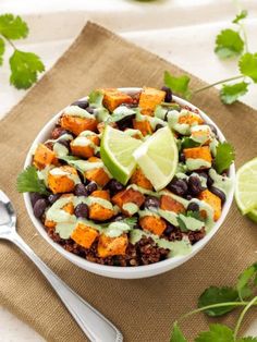 a white bowl filled with black beans, sweet potatoes and avocado garnish