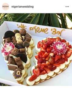 a heart shaped cake with strawberries and chocolates on it