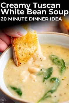 a bowl of creamy white bean soup with a piece of bread sticking out of it