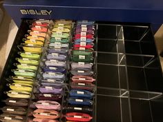 many different colored spools of thread on display in a store shelf with plastic bins