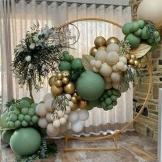 an arrangement of balloons and greenery on a stand