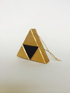 a gold triangle shaped object with a black triangle on it's front and side