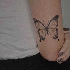 a woman's arm with a butterfly tattoo on the left side of her body