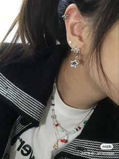 a woman wearing two star shaped earrings on her ear