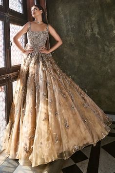 a woman standing in front of a window wearing a dress with sequins on it