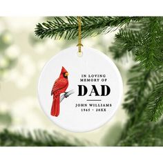 a personalized christmas ornament with a cardinal perched on a pine tree branch