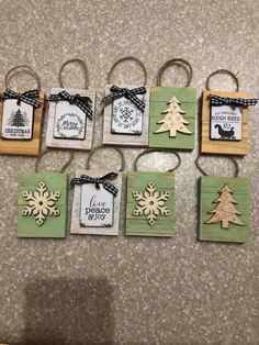 small christmas ornaments are hanging on the wall in front of a counter with tags attached to them