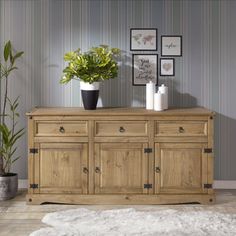 a large wooden cabinet with two plants on top