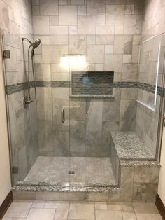 a walk in shower sitting inside of a bathroom next to a tiled floor and walls