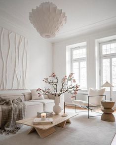 a living room filled with furniture and a large white vase on top of a coffee table