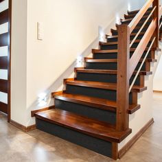 a set of wooden stairs with lights on them in a house or office area,