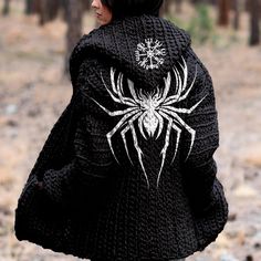 a woman wearing a black sweater with white spider - man on it