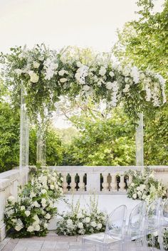 an outdoor wedding setup with white flowers and greenery