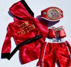 a boxing outfit and gloves are laying next to each other on a white table top